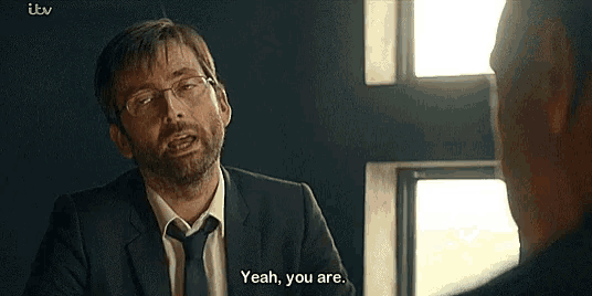 a man in a suit and tie is talking to another man and saying yeah , you are .