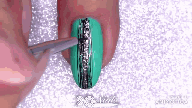 a person is applying nail polish to a green nail with a brush