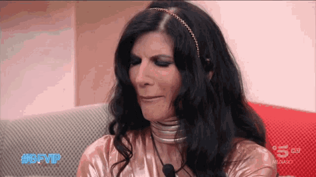 a woman sitting on a couch with #gfvip written on her face