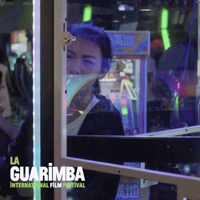 a poster for la guarimba international film festival shows a woman in an arcade