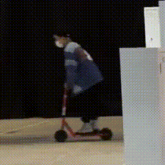 a person wearing a face mask is riding a scooter