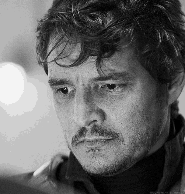 a black and white photo of a man with a beard and a turtleneck sweater