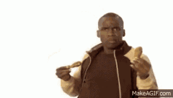 a man is eating chicken wings and listening to music with headphones .