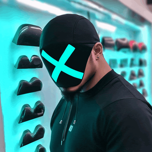 a man wearing a black mask with a blue cross on it