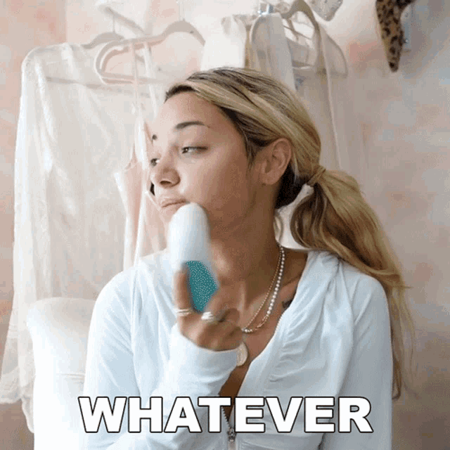 a woman with a ponytail is holding a brush in her hand and the word whatever is above her