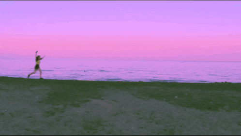 a silhouette of a person running on a sandy beach
