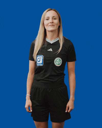 a woman wearing a black adidas shirt and shorts is standing in front of a blue background