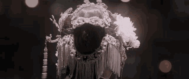 a woman is wearing a very elaborate costume with flowers and pearls .