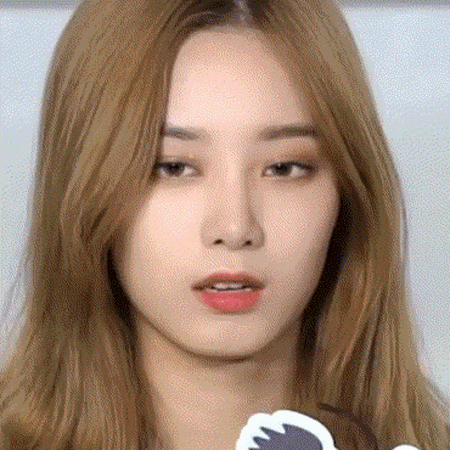 a close up of a woman 's face with long hair and red lips .