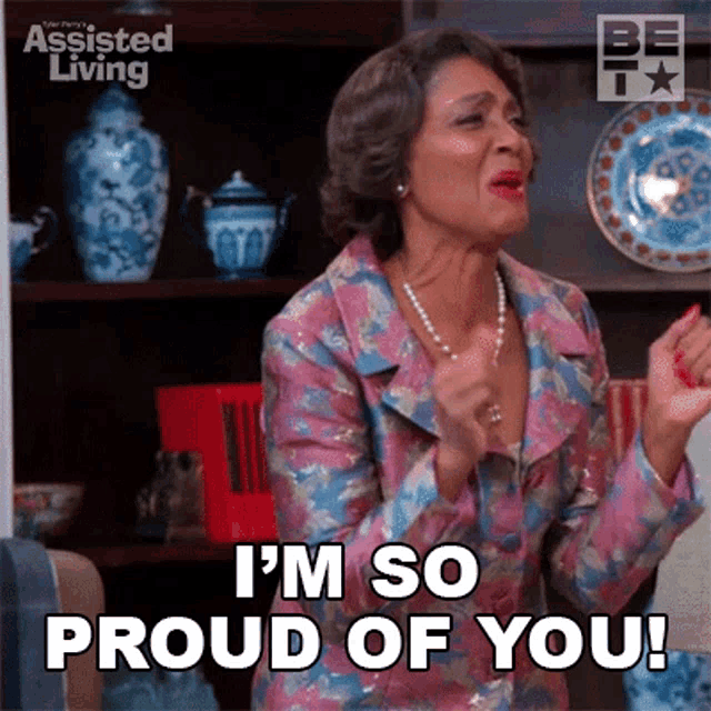 a woman in a floral suit is saying i 'm so proud of you !
