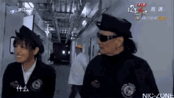 a man and a woman are standing in a hallway .
