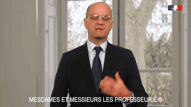 a man in a suit and tie is speaking in french