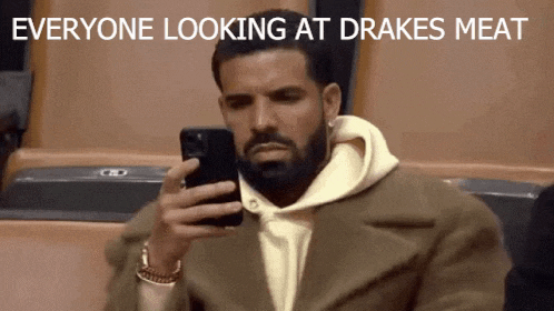 a man with a beard is looking at his phone with the words everyone looking at drake 's meat below him