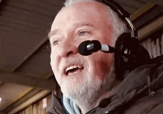 a man with a beard is wearing headphones and a microphone on his head .