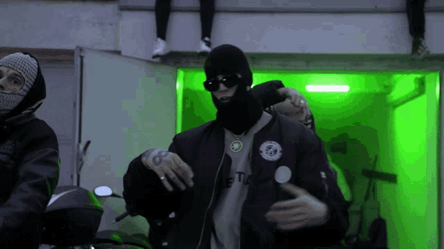 a man wearing sunglasses and a jacket that says etio
