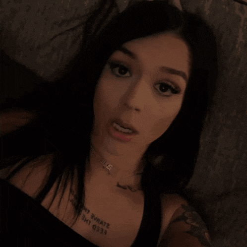 a woman with a tattoo on her chest that says ' i am queen ' on it