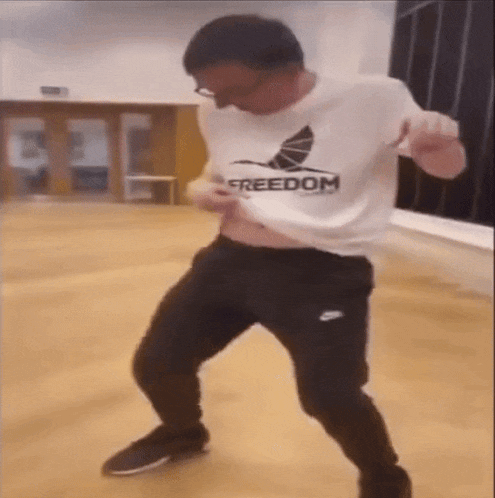 a man wearing a freedom shirt is dancing in a gym