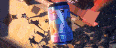 a can of soda is sitting on a table in front of a crowd of people .