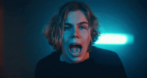 a close up of a person 's face with a blue light behind them