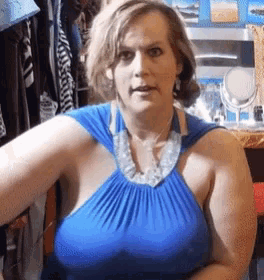 a woman wearing a blue top and a silver necklace