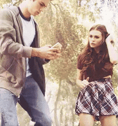 a man and a woman are standing next to each other in a park .