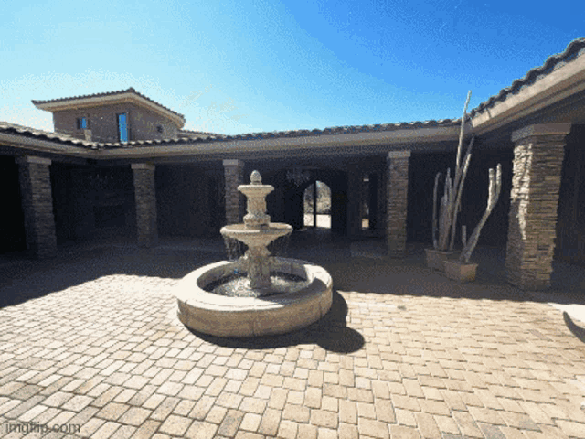 a fountain in the middle of a courtyard with images.com written on the bottom