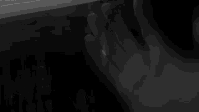 a black and white photo of a person typing on a laptop