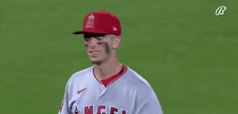 a baseball player is wearing a red hat and smiling .