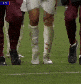 a group of soccer players standing on a field with the word liv on the bottom