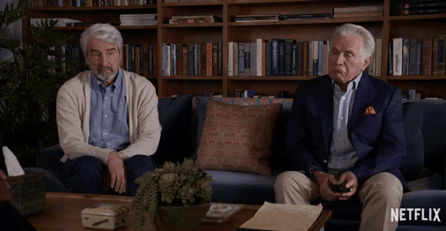 two men sit on a couch with a netflix logo on the bottom