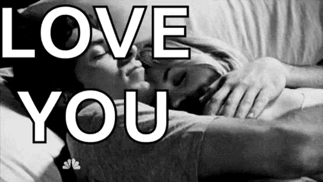 a black and white photo of a man and a woman hugging each other in bed .
