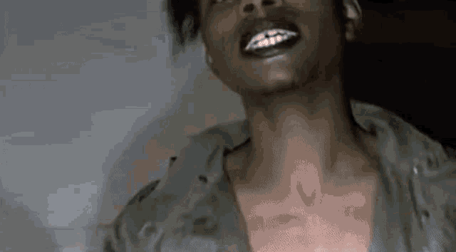 a close up of a man 's neck and chest with his mouth open and teeth showing .