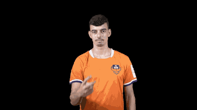 a man wearing an orange shirt with a lion on the front