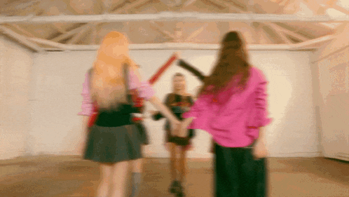 a blurry picture of three women standing in a room holding hands