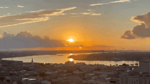 a sunset over a city with a large body of water