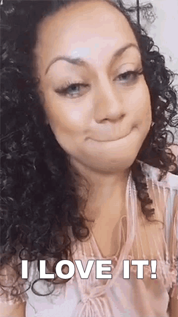 a woman with curly hair is making a face and saying i love it !