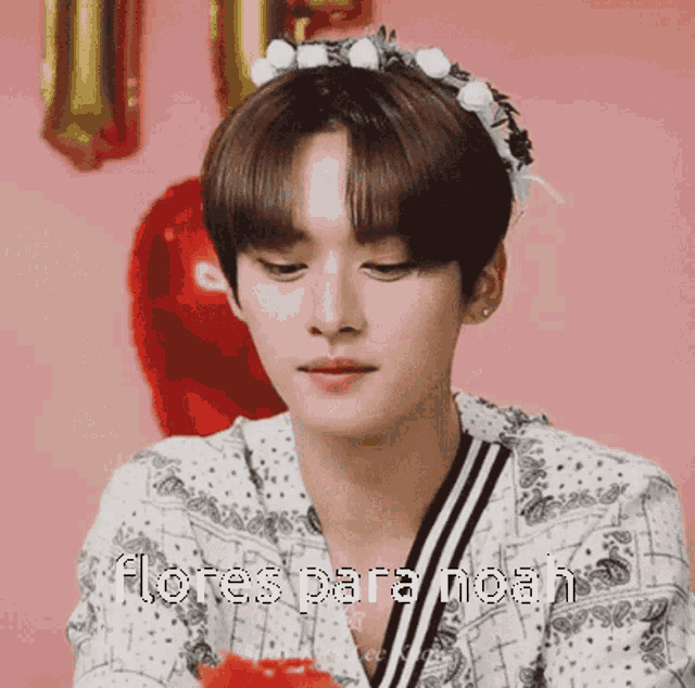 a young man wearing a flower crown with the words flores para noah written on it