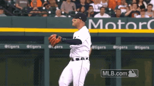 a baseball player stands in front of a sign that says motorc