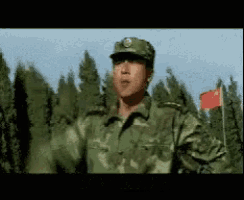 a soldier is standing in front of a red flag