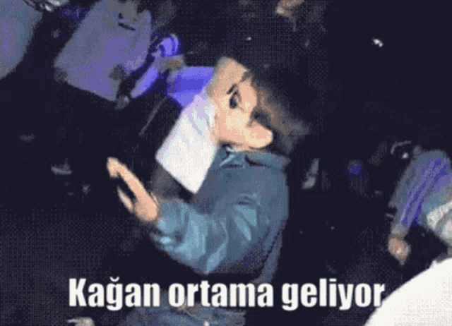 a boy wearing sunglasses and a tattoo on his forehead says kagan ortama geliyor on the bottom