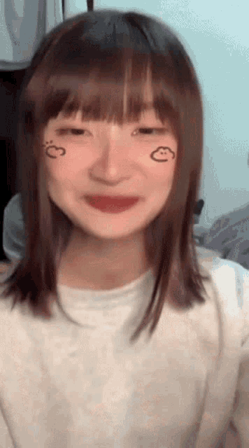 a girl with a heart drawn on her face is smiling