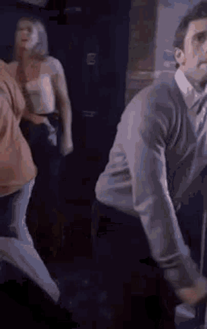 a group of people are dancing in a dark room in a club .