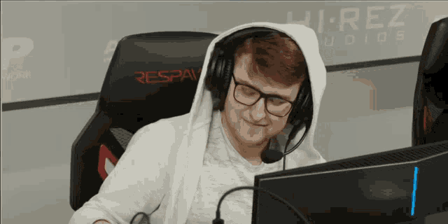 a man wearing headphones and glasses is sitting in a chair that says respaw on it