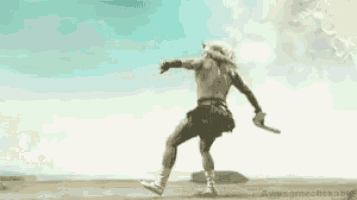 a man in a bikini is running on a beach in the desert .