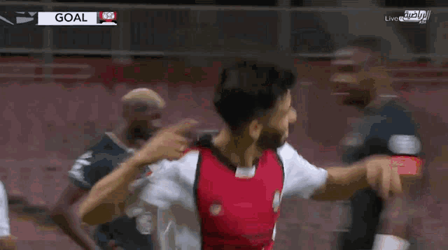 a soccer player in a red and white jersey celebrates a goal with his teammates