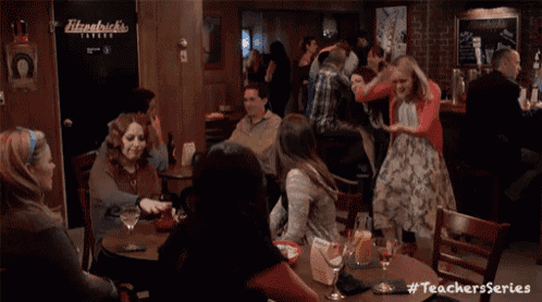 a group of people are dancing in a restaurant with a sign that says fitzpatrick 's on it