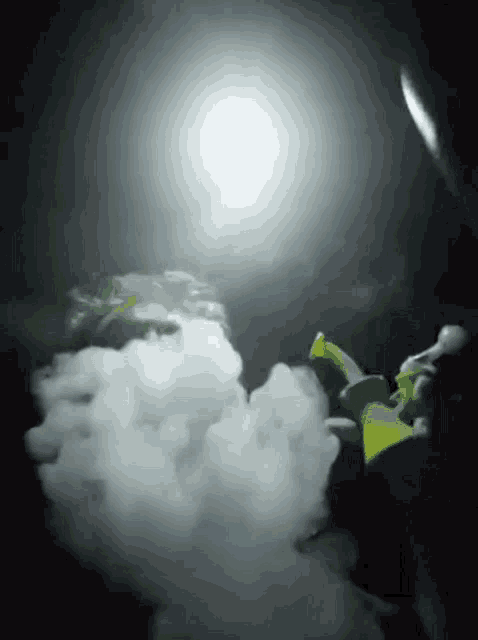 a green and white object is surrounded by smoke