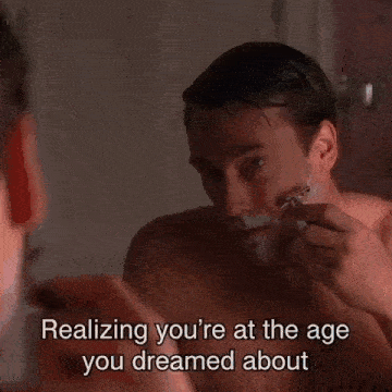 a man is standing in front of a window with the words realizing you 're at the age you dreamed about