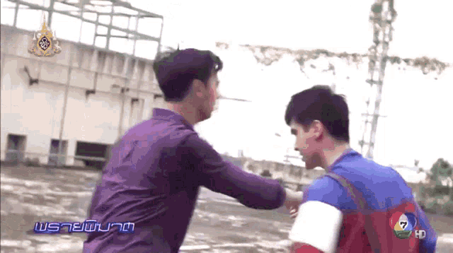 a man in a purple shirt is standing next to another man in a blue and white shirt ..