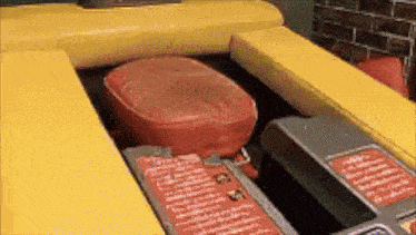 a red pillow is sitting on top of a yellow couch .